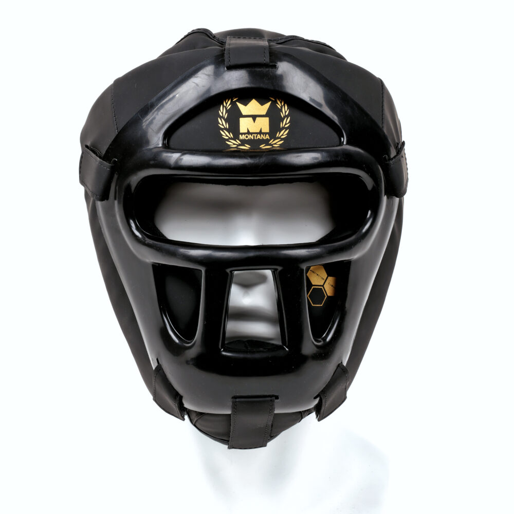 Casque de boxe noir Montana FACESHIELD PROTECTOR NewCode vu de face, montrant la grille de protection faciale monobloc et le blason doré Montana sur le front.