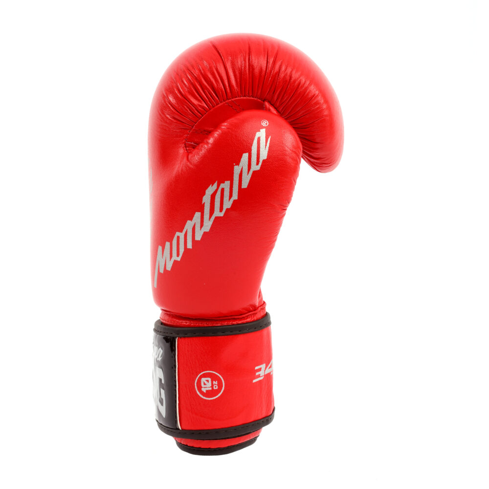 Gant de boxe rouge Montana 34ST NewCode vu de profil, poing fermé, avec la signature Montana blanche sur le flanc et la manchette noire à scratch.