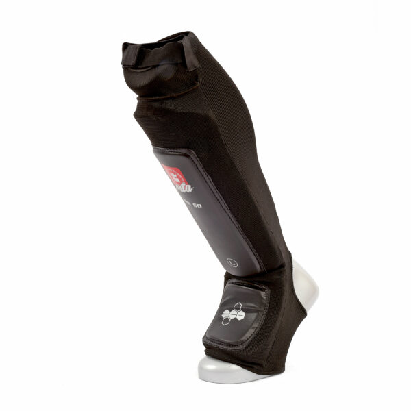 Protège tibias MK50 Absorb noir avec coup de pied intégré, mousse dense et renforts, conçu pour une absorption maximale pendant les entraînements intensifs.