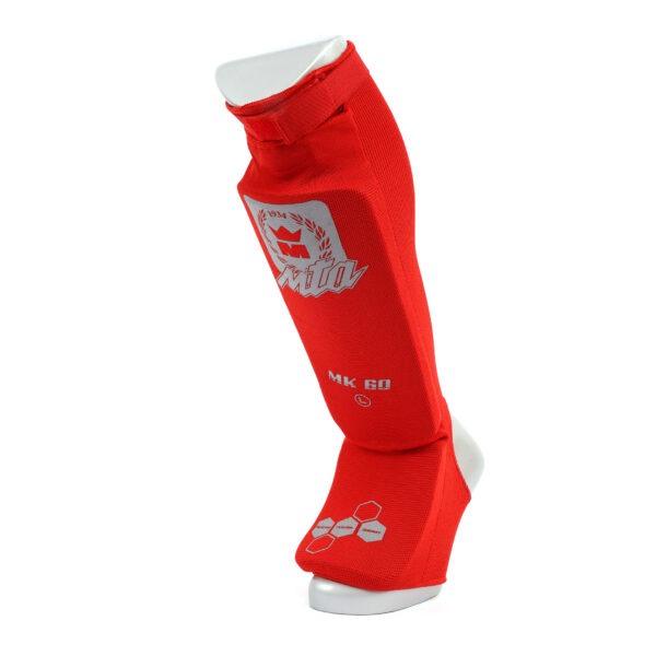Protège tibias rouge MK60 avec pied intégré, confort coton et absorption renforcée, système de serrage scratch et certification CE pour les sports de combat.