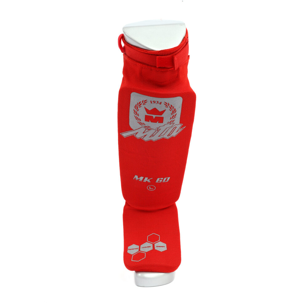 Protège tibias rouge MK60 avec pied intégré, confort coton et absorption renforcée, système de serrage scratch et certification CE pour les sports de combat.
