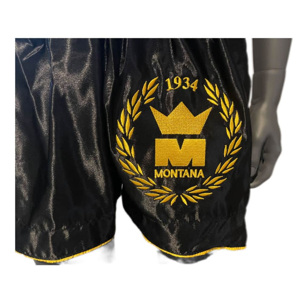 Short de boxe noir MULTIBOX NewCode en satin polyester, coupe classique adaptée au Kick et Muay Thai, confortable et léger.