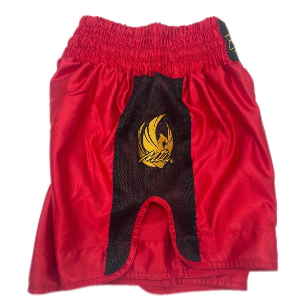 Short Muay Thai rouge NewCode en satin polyester, avec bande latérale mesh VENTIL’AIR pour une meilleure ventilation, large ouverture et ceinture élastique.