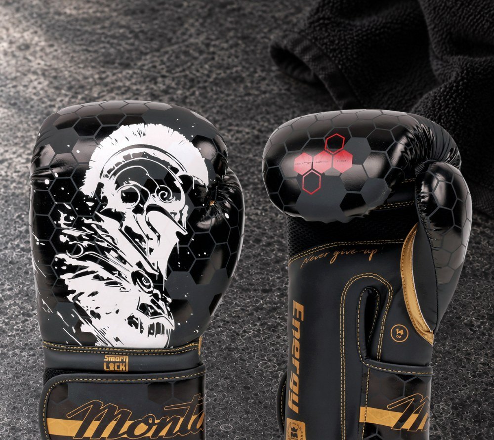Paire de gants de boxe ENERGY Spartiate noirs et or posés sur un banc en béton