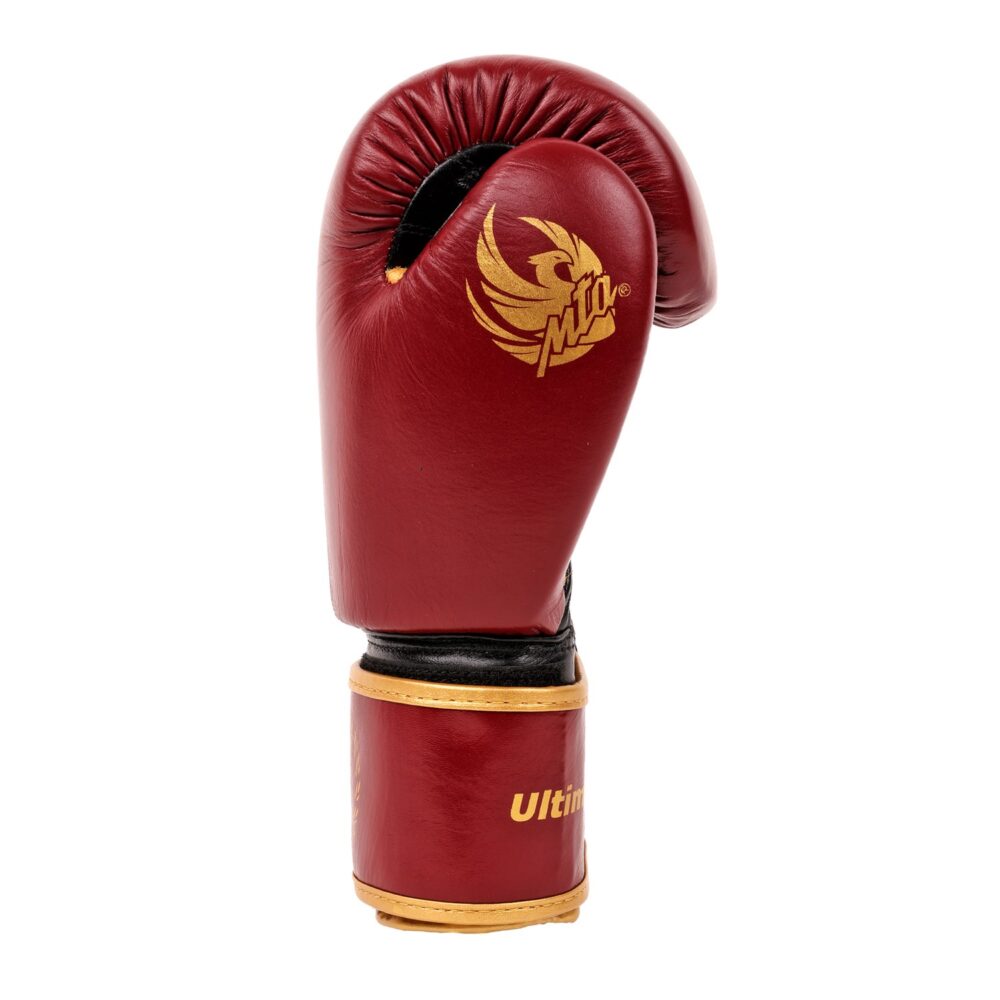 Gant de boxe bordeaux Montana ULTIMATE Legend vu de profil, poing fermé sur le grip Roll Gripp, avec le phénix doré imprimé sur le côté et la manchette SMARTLOCK.