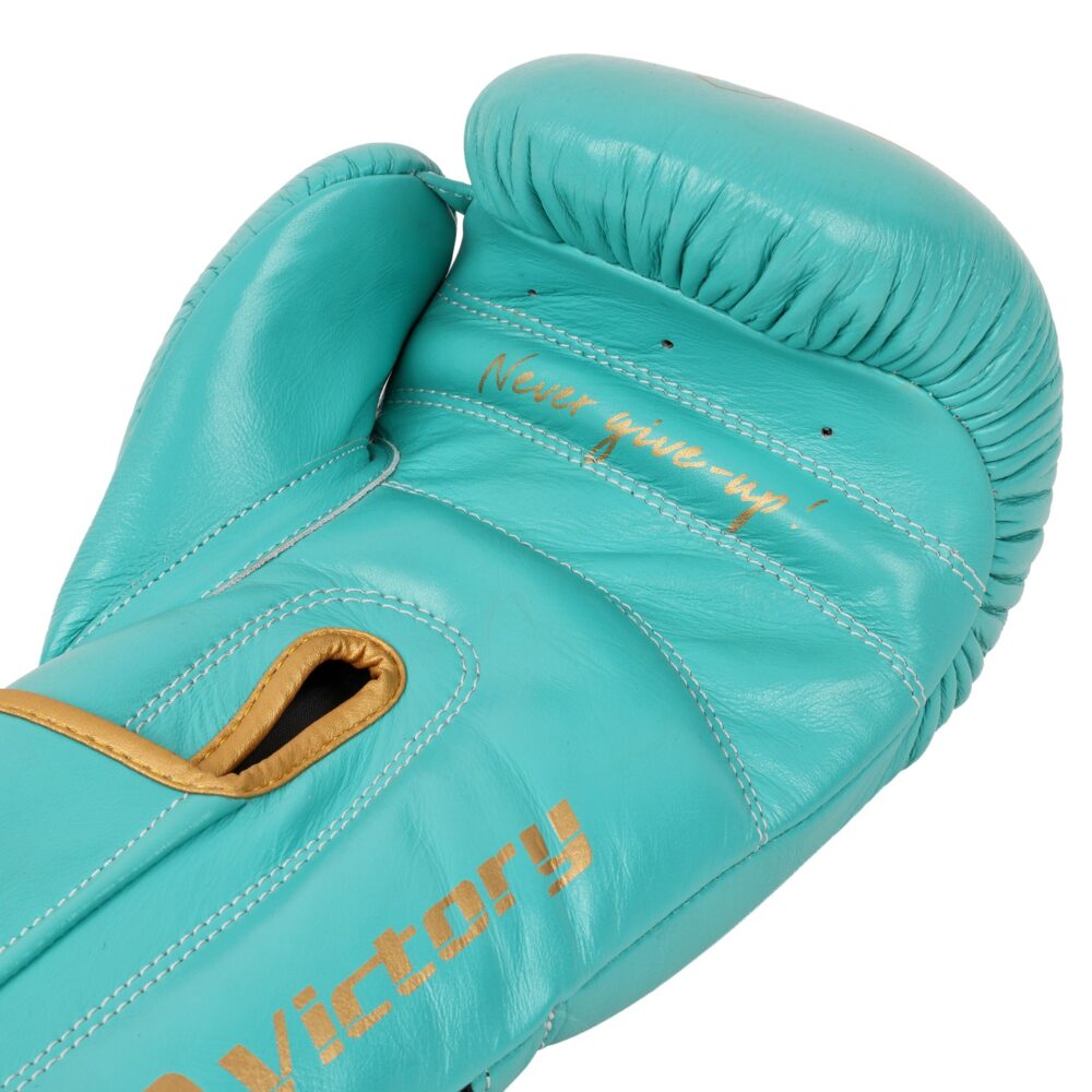 Détail macro du gant de boxe Montana VICTORY Limited lagoon : grain du cuir de vachette turquoise, surpiqûres dorées et lettrage Victory sur la manchette.