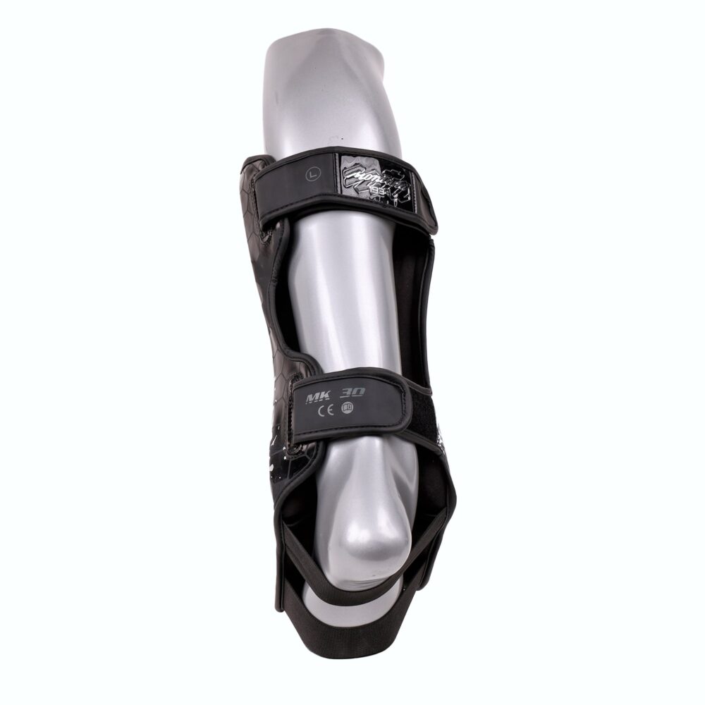 Protège-tibia Montana MK30 Spartiate vu de l'arrière sur une jambe de mannequin, montrant les deux bandes élastiques réglables à fermeture scratch qui assurent le maintien.