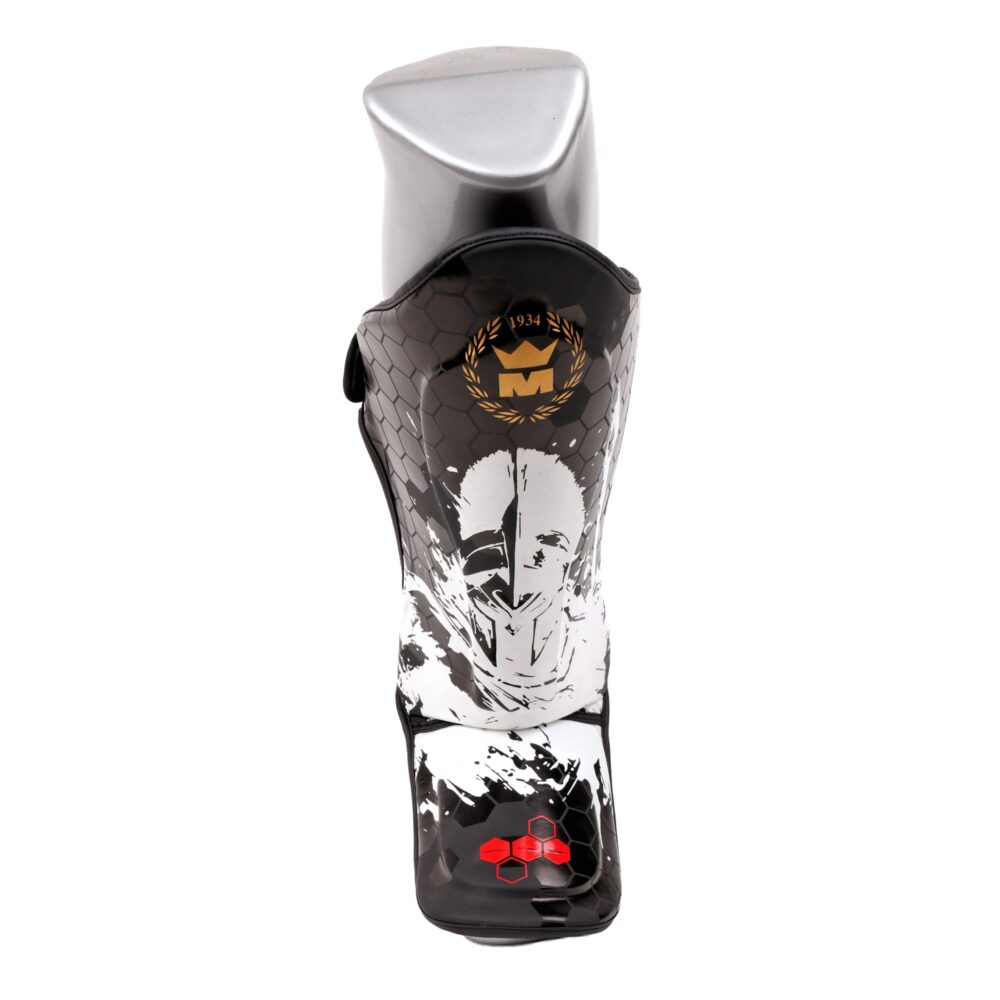 Protège-tibia Montana MK30 Spartiate porté sur une jambe de mannequin, vu de face, montrant le motif du guerrier spartiate et la coque de protection du coup de pied.